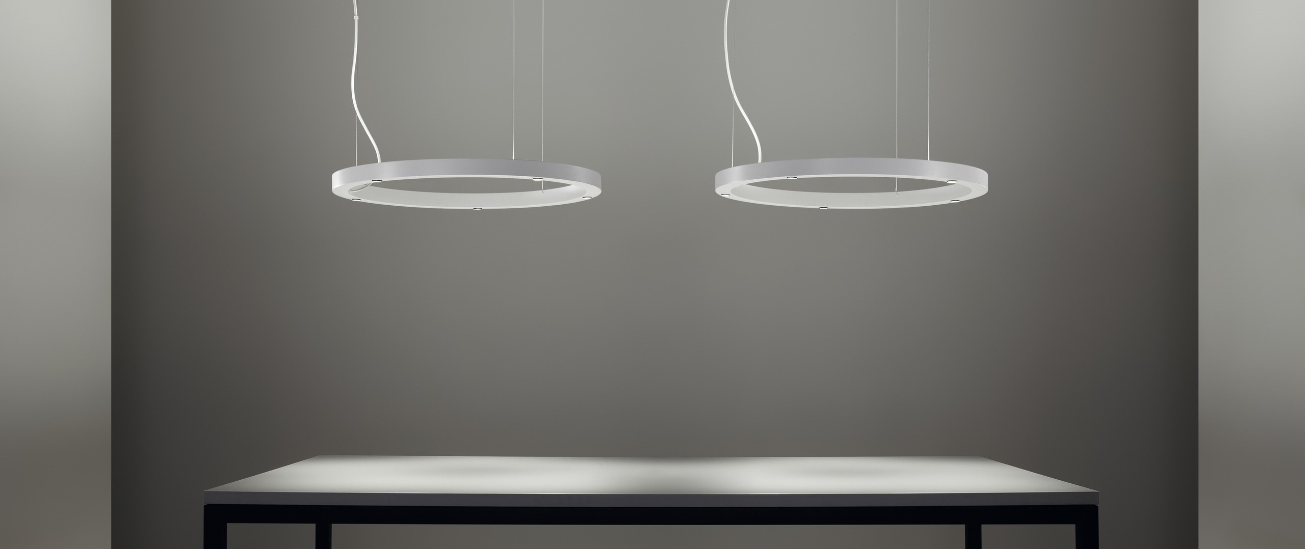 circular design suspension light Lámpara de suspensión TR diseñada por Josep Lluís Xuclà para Insòlit, una lámpara de suspensión circular de diseño contemporáneo. Esta lámpara de suspensión destaca por su perfil de aluminio extruido y curvado, combinado con un difusor de policarbonato gel que suaviza la iluminación, ideal para proyectos de iluminación a medida y lámparas a medida. La lámpara de suspensión TR es totalmente personalizable y perfecta para crear combinaciones de lámparas suspendidas o lámparas flotantes combinables en lobbis de hotel, recepción y grandes espacios. Como lámpara de gran escala y lámpara de diseño exclusiva, la TR aporta funcionalidad y estilo en proyectos de lighting design, iluminación a medida y decoración de interiores. Este modelo de lámpara de suspensión circular permite múltiples combinaciones con otras lámparas suspendidas, facilitando composiciones únicas para lobbis de hotel, recepciones y grandes salones. La lámpara de suspensión TR de Insòlit es la elección ideal para quienes buscan lámparas combinables suspendidas, iluminación a medida y productos de alta calidad en lámparas de diseño y lighting design. TR suspension lamp designed by Josep Lluís Xuclà for Insòlit is a circular suspension lamp with a contemporary design. This suspension lamp features an extruded and curved aluminum profile combined with a gel polycarbonate diffuser that softens the lighting, perfect for bespoke lighting and custom lamps projects. The TR suspension lamp is fully customizable and ideal for creating combinations of suspended lamps or combinable floating lamps for hotel lobbies, receptions, and large spaces. As a large-scale lamp and designer lamp, the TR provides functionality and style in lighting design, bespoke lighting, and interior decoration projects. This circular suspension lamp model allows multiple combinations with other suspended lamps, enabling unique compositions for hotel lobbies, receptions, and large halls. The Insòlit TR suspension lamp is the perfect choice for those looking for combinable suspended lamps, bespoke lighting, and high-quality products in designer lamps and lighting design.